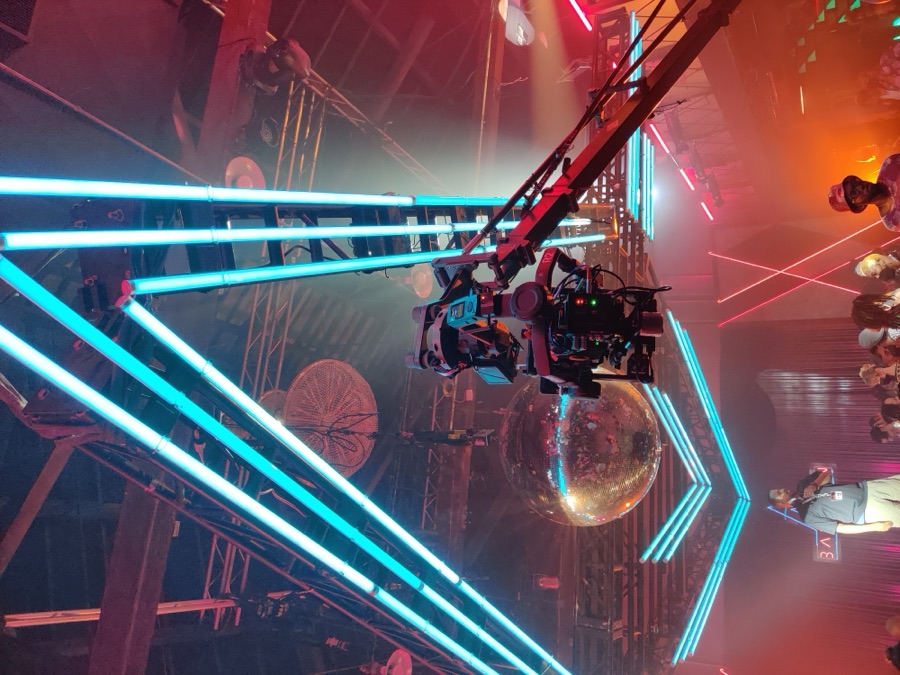 Neon-lit music video set with jib