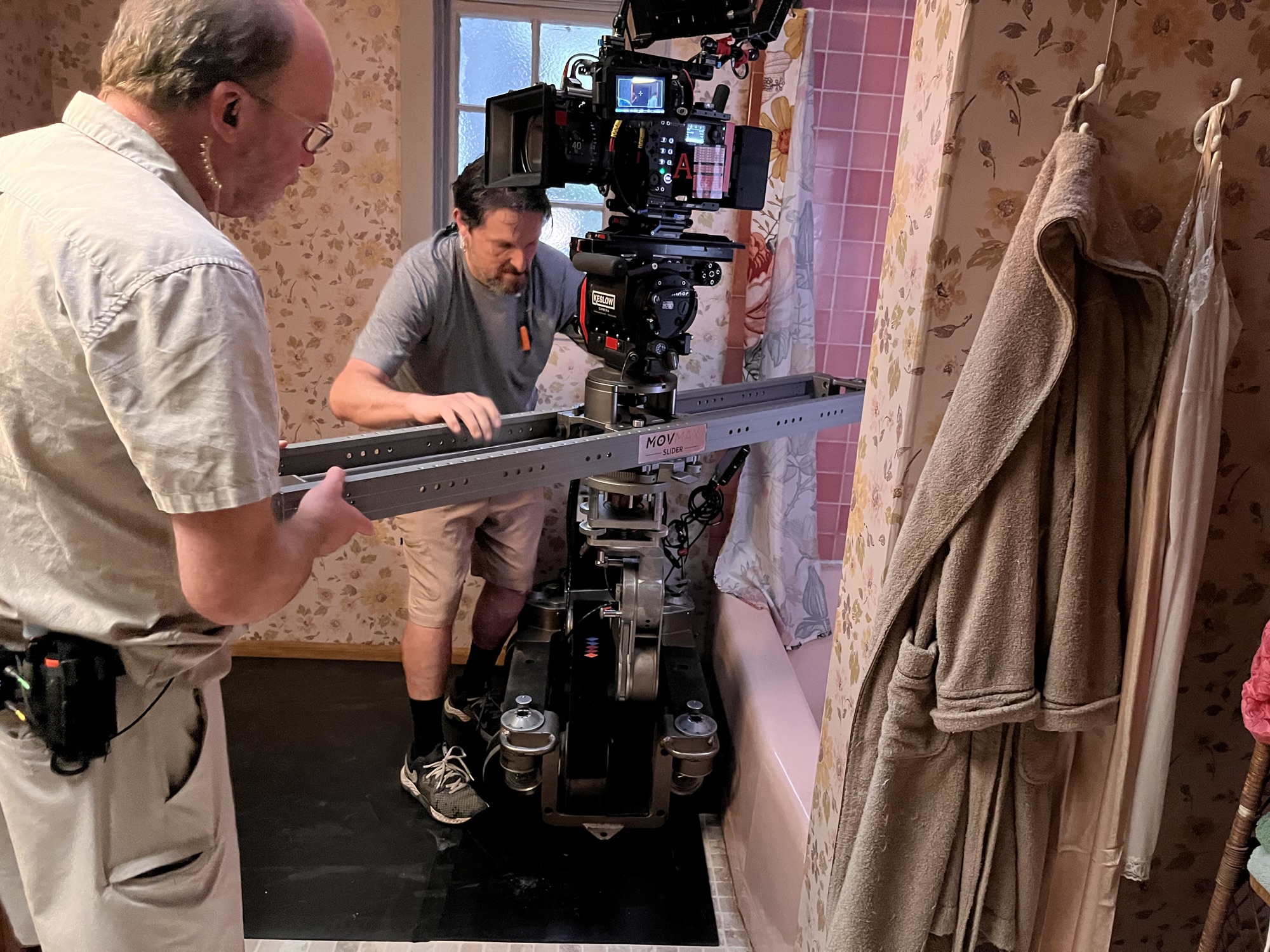 Camera slider rigged over a bathtub on a practical location set