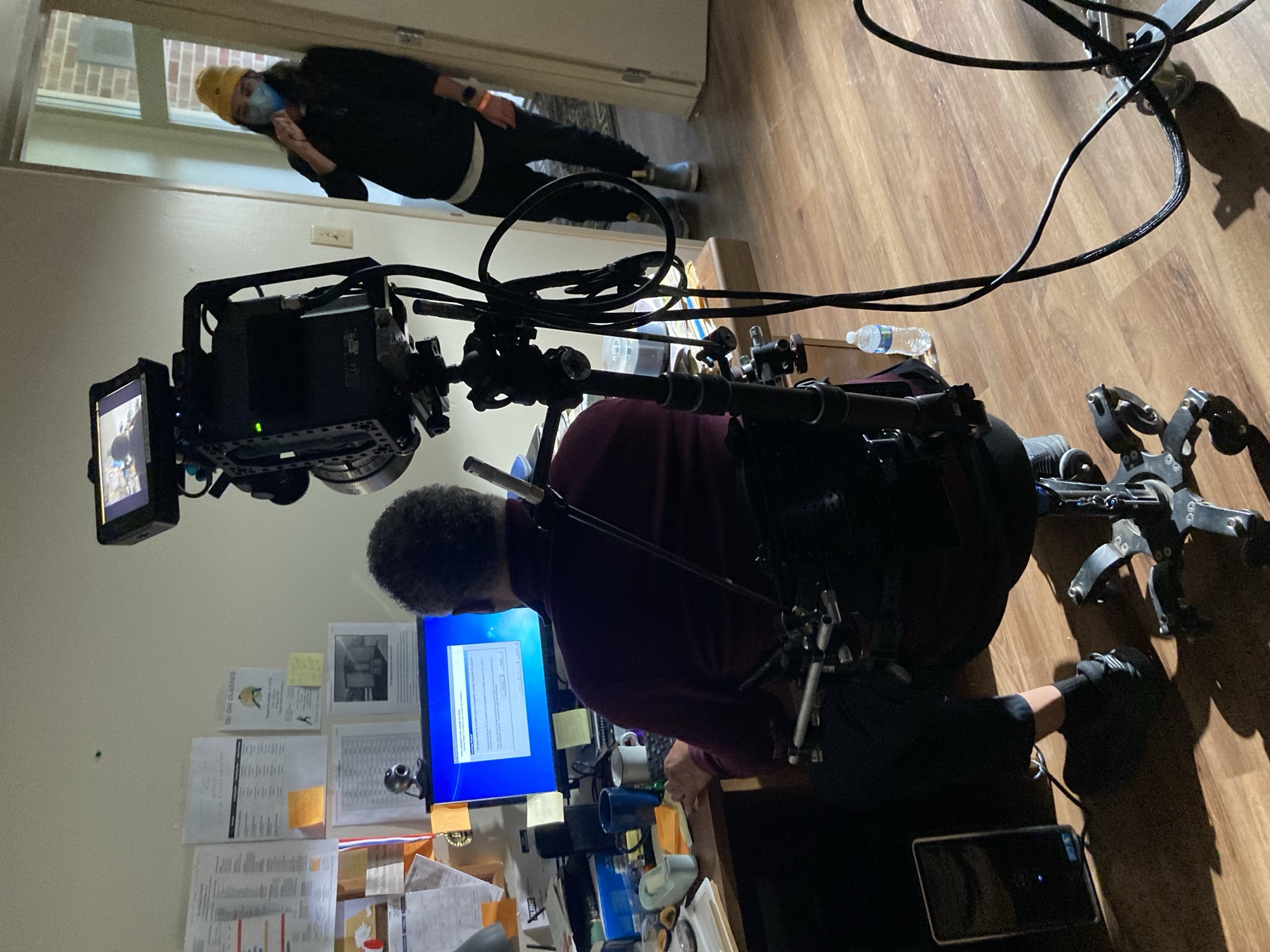 Snorricam body rig mounted on an actor at a desk, camera facing back at him